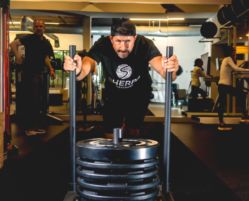 Athlete pushing weighted sled during strength training workout at Sherpa personal training studio in Westport CT
