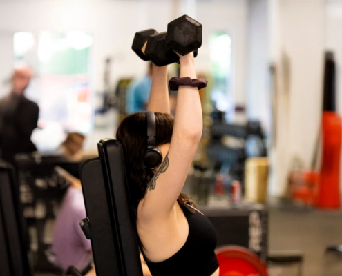 Woman lifting dumbbells during personal training workout at Sherpa in Westport CT