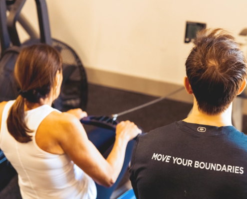 Rower training with Sherpa coach in Westport, CT wearing Move Your Boundaries shirt during September rowing challenge.