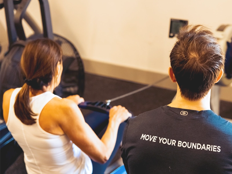 Rower training with Sherpa coach in Westport, CT wearing Move Your Boundaries shirt during September rowing challenge.