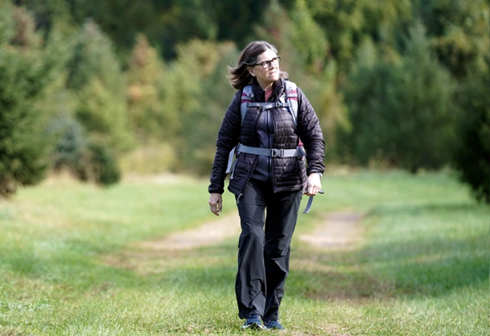 Woman hiking in the forest symbolizing Sherpas nutrition coaching and whole-body wellness in Westport CT.