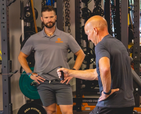 Certified personal trainer at Sherpa in Westport CT coaching client on cable row exercise for strength and fitness program