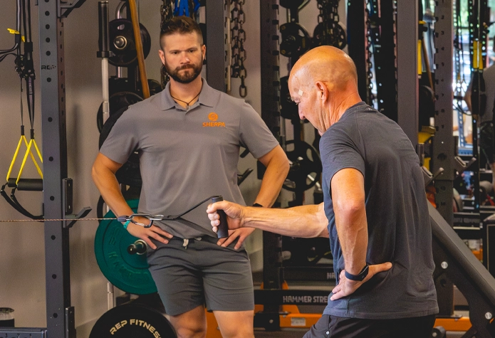 Certified personal trainer at Sherpa in Westport CT coaching client on cable row exercise for strength and fitness program