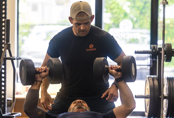 Steve Hendry, certified personal trainer at Sherpa in Westport CT, supervising a client during strength training.