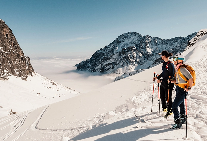 Backcountry skier with a certified guide on an alpine slope; Yonderey connects mountain enthusiasts with trusted guides across North America.