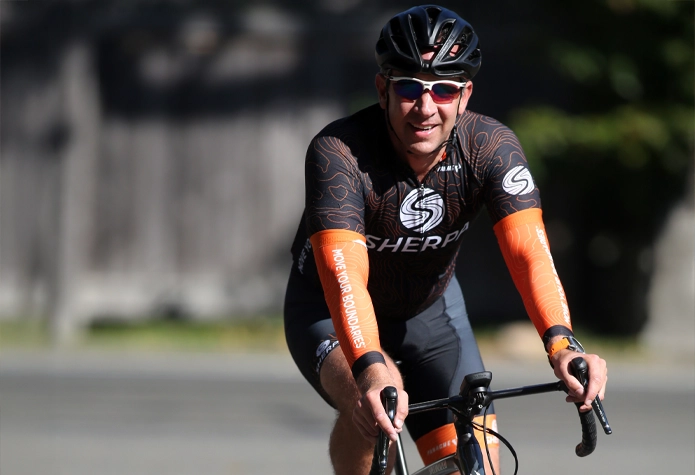 Cyclist wearing Sherpa kit riding outdoors, representing functional fitness training that supports cycling performance beyond the gym in Westport, CT.