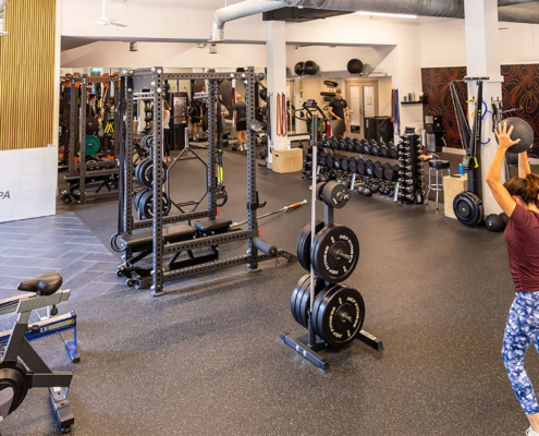 Open training floor at Sherpa, a gym in Westport, CT, with an athlete tossing a weighted ball