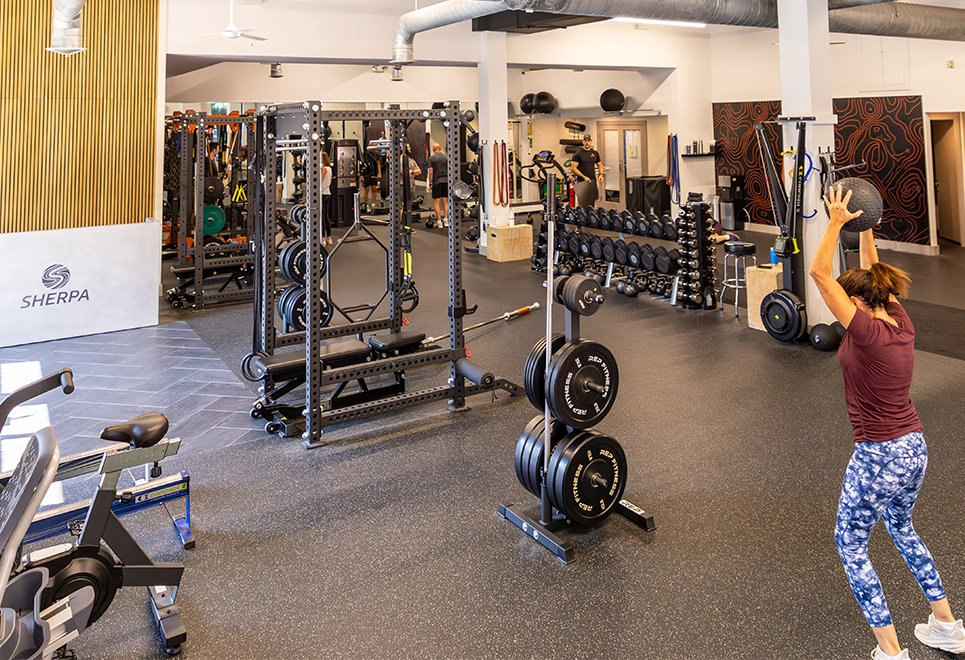 Open training floor at Sherpa, a gym in Westport, CT, with an athlete tossing a weighted ball