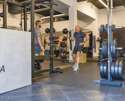 Coach guiding an active adult through strength training at Sherpa in Westport, CT.