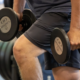 Active adult man performing a dumbbell split squat at Sherpa in Westport, CT with front knee bent at 90 degrees and back leg extended behind him