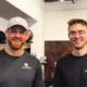 Two Sherpa fitness trainers smiling and wearing branded shirts at the gym, showcasing the friendly, personalized coaching experience that helps clients build strength and confidence beyond the gym.