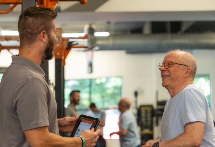 Sherpa Fitness trainer discussing a longevity training plan with an older client in Westport, CT